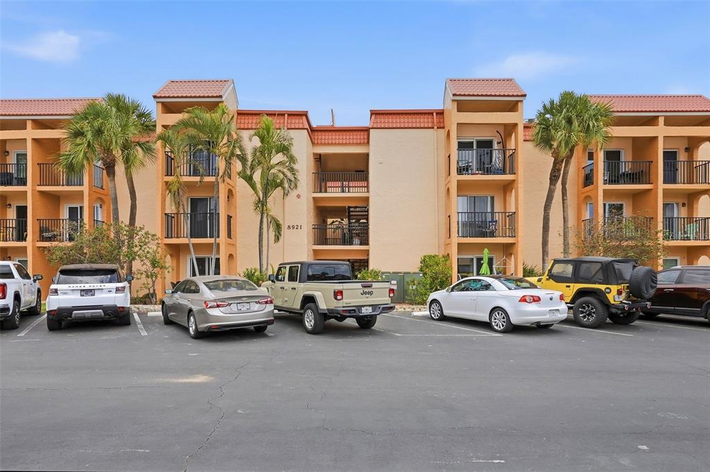 8921 Blind Pass Road, Unit 144 St. Pete Beach, FL 33706 - Photo 33 of 37 a cars parked in front of a building