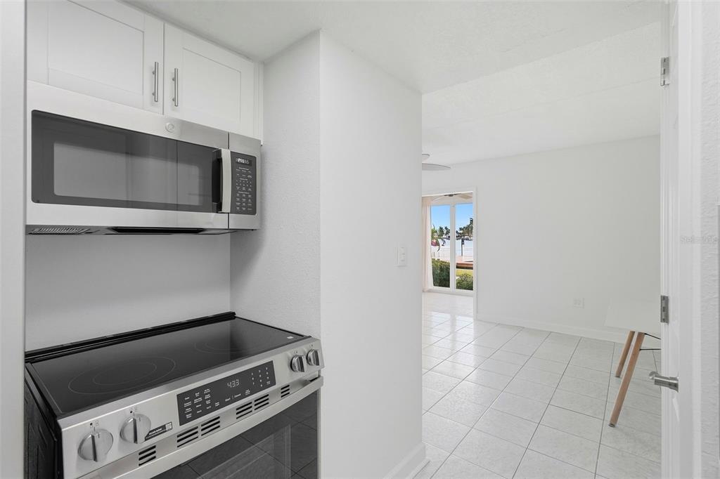 8921 Blind Pass Road, Unit 144 St. Pete Beach, FL 33706 - Photo 5 of 37 a kitchen with a stove and a microwave