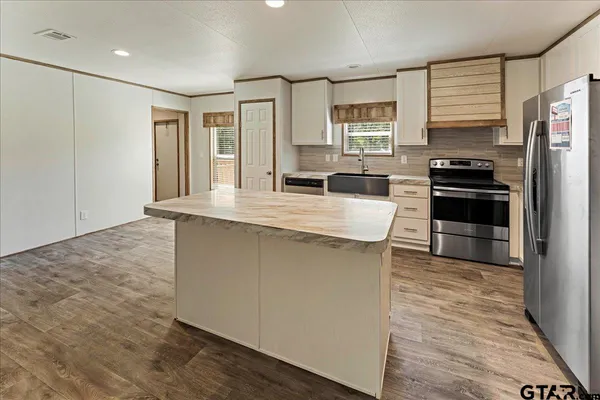 a kitchen with stainless steel appliances granite countertop a stove and a refrigerator