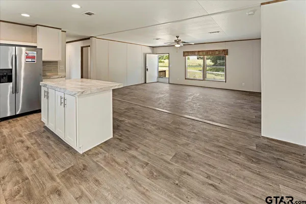 a kitchen with granite countertop a stove a refrigerator and a microwave oven