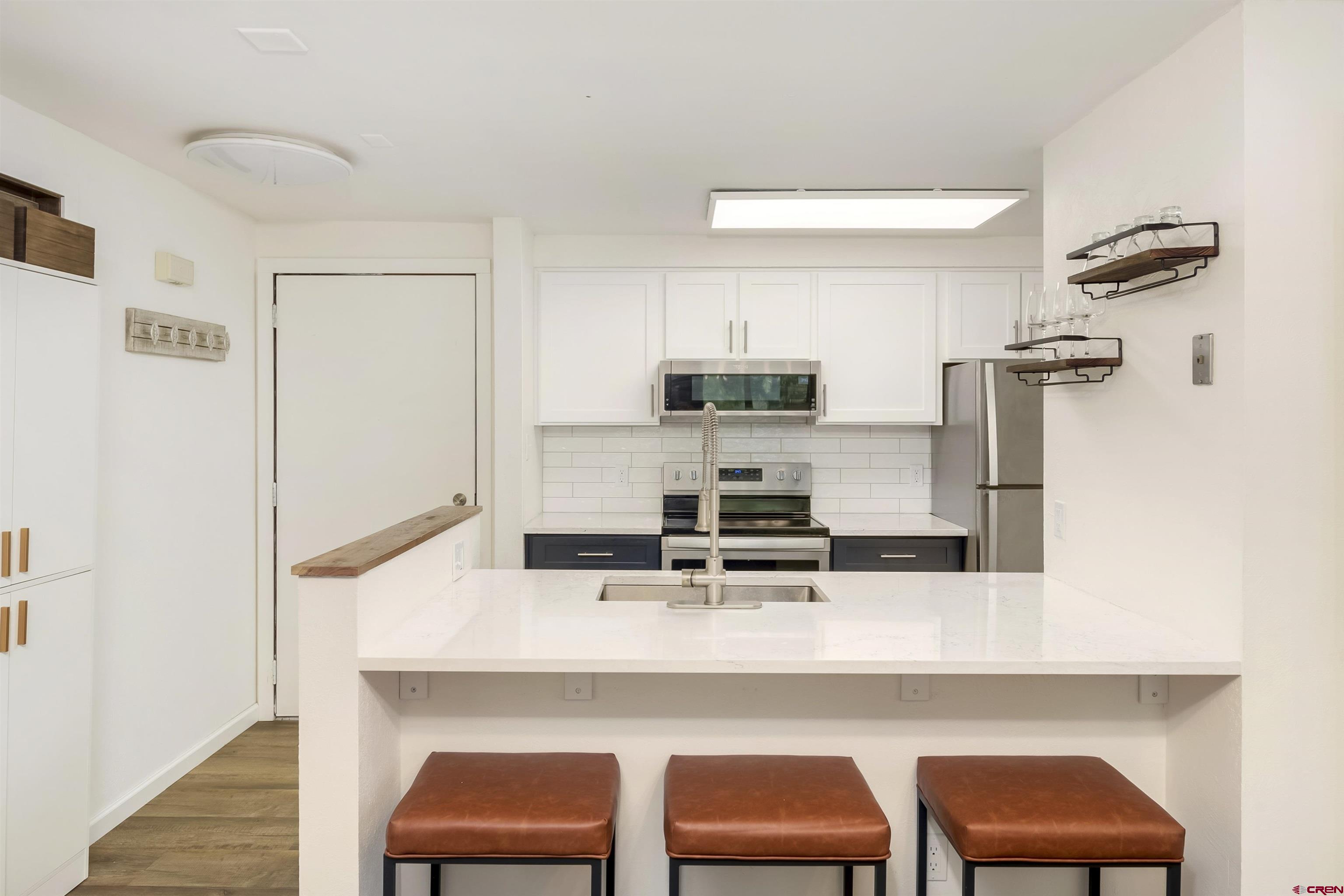 651 Gothic Road, Unit 511 Crested Butte, CO 81225 - Photo 16 of 34 a kitchen with stainless steel appliances a sink and chairs