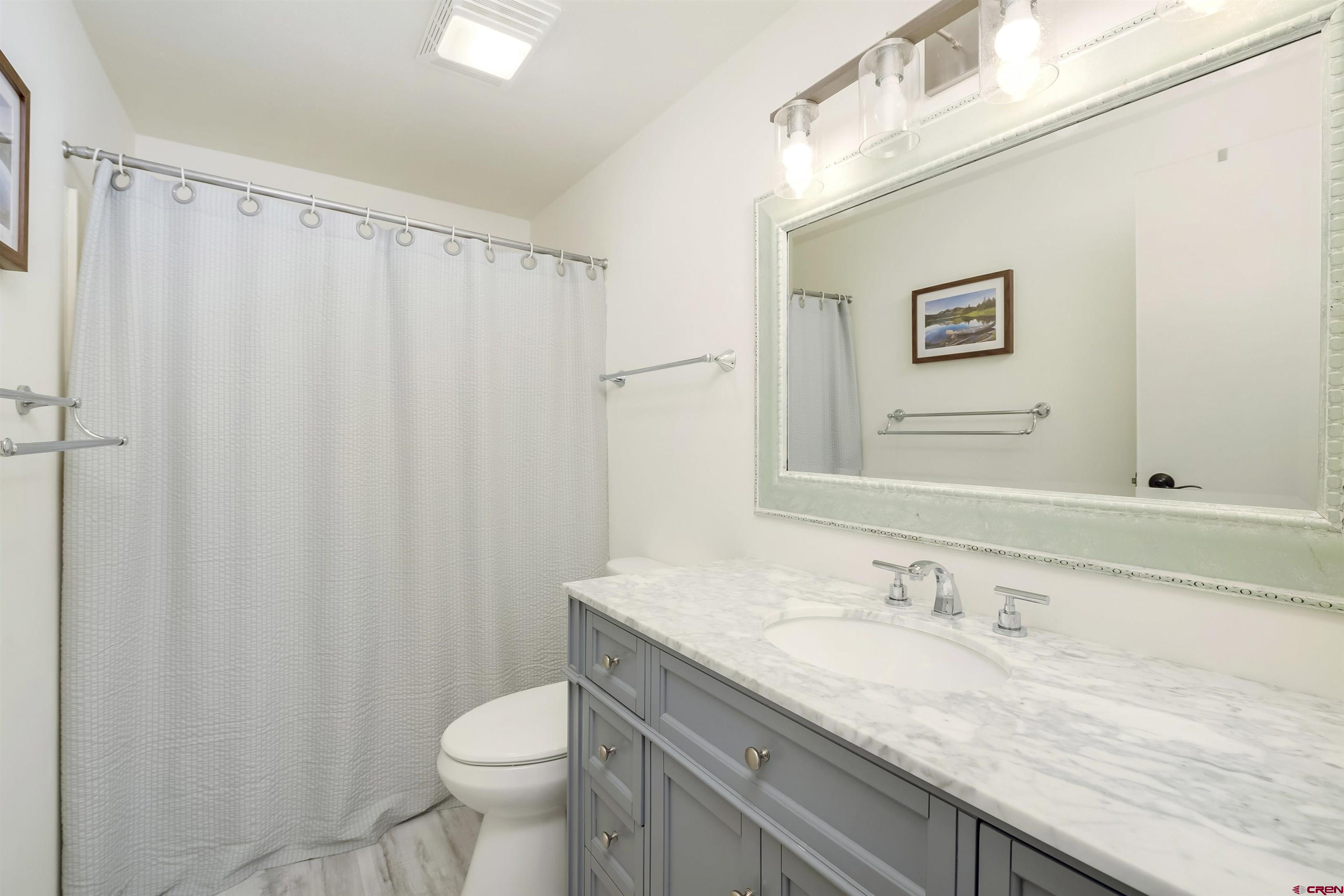 651 Gothic Road, Unit 511 Crested Butte, CO 81225 - Photo 22 of 34 a bathroom with a granite countertop sink toilet and a mirror