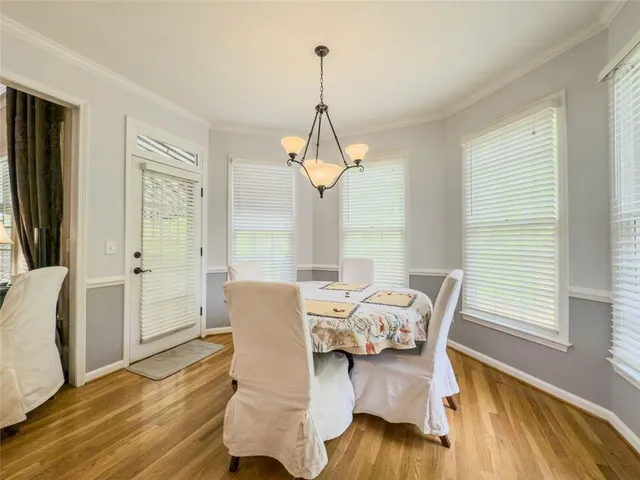 a large kitchen with a refrigerator a sink dishwasher a stove and white cabinets with wooden floor