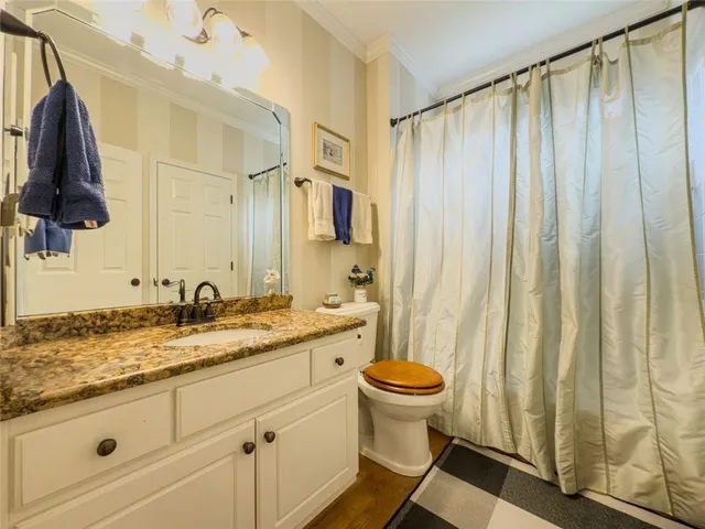 a spacious bathroom with a granite countertop sink and a mirror