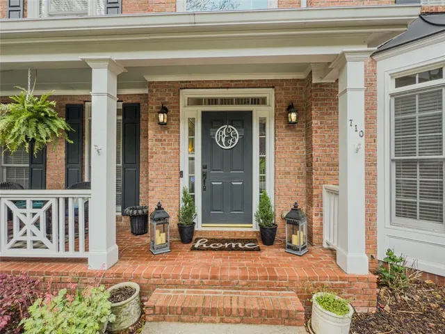 a front view of a house with potted plants