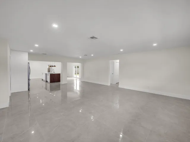 a view of empty room with kitchen