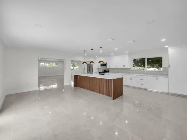 a large kitchen with a sink and cabinets