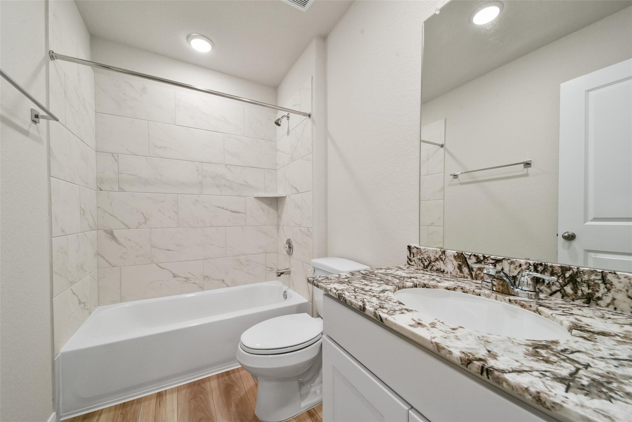 10522 Plumas Run Drive Rosharon, TX 77583 - Photo 24 of 29 Sophisticated modern bathroom featuring elegant marble-patterned tile and a striking granite vanity for a perfect blend of style and function.