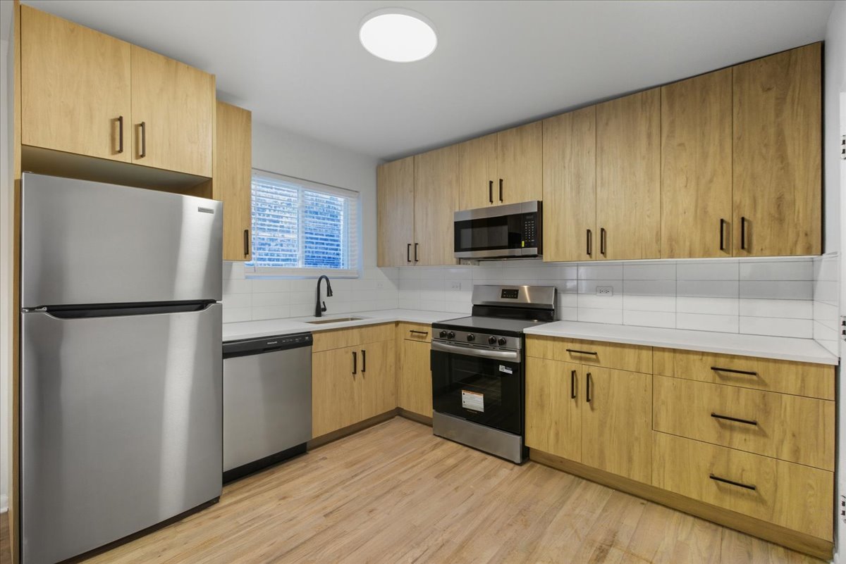 7357 North Winchester Avenue, Unit 2M Chicago, IL 60626 - Photo 2 of 10 a kitchen with granite countertop a refrigerator stove top oven and sink