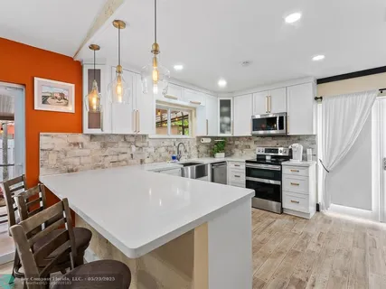 a kitchen with a refrigerator a stove a sink and a microwave