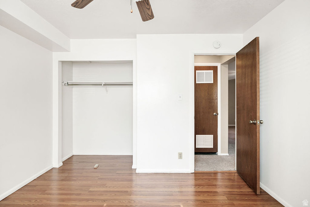 240 East 400 North, Unit 26 Logan, UT 84321 - Photo 8 of 12 Room featuring wood-finish flooring, a built-in closet with hanging rod, and a ceiling fan with wood-finish blades