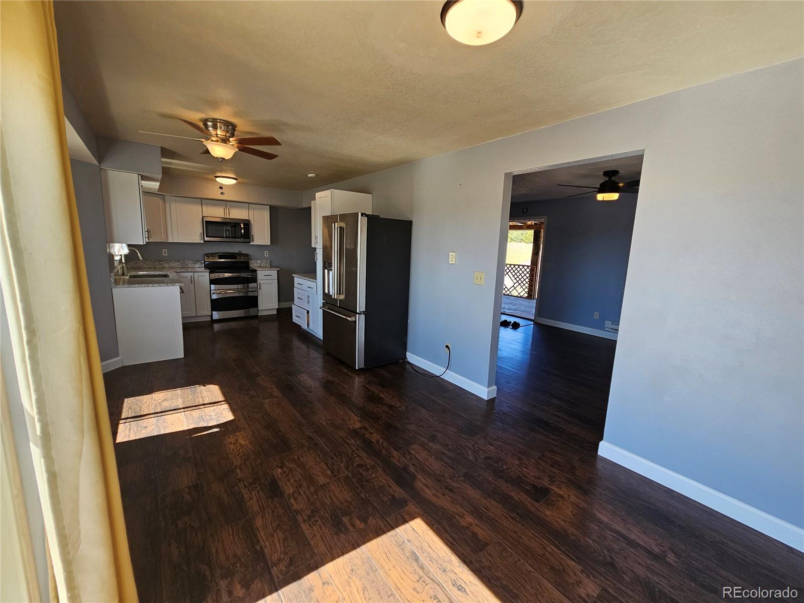 16985 Sage Crest Road Peyton, CO 80831 - Photo 6 of 25 a kitchen with stainless steel appliances refrigerator and microwave