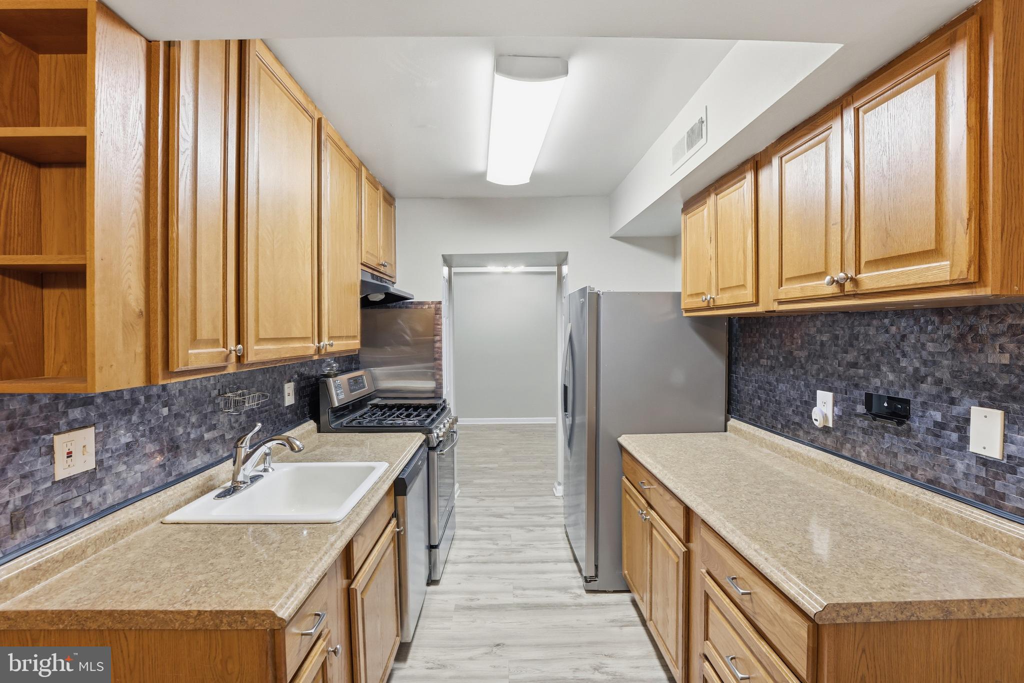 11242 Cherry Hill Road, Unit 1 Beltsville, MD 20705 - Photo 12 of 31 a kitchen with stainless steel appliances granite countertop a sink a refrigerator and a stove