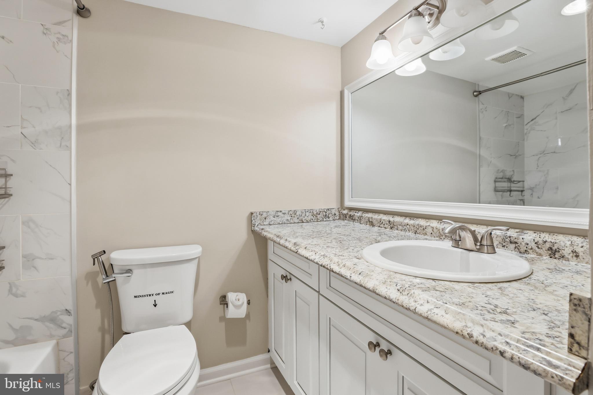 11242 Cherry Hill Road, Unit 1 Beltsville, MD 20705 - Photo 17 of 31 a bathroom with a granite countertop toilet sink and mirror