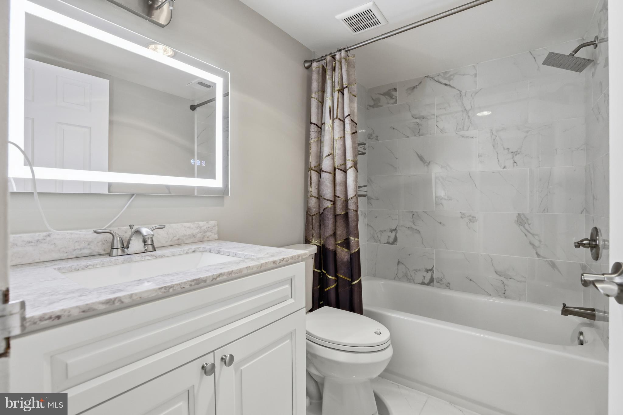 11242 Cherry Hill Road, Unit 1 Beltsville, MD 20705 - Photo 25 of 31 a bathroom with a granite countertop toilet sink and bathtub