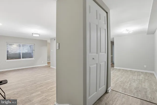 an empty room with wooden floor and a bathroom