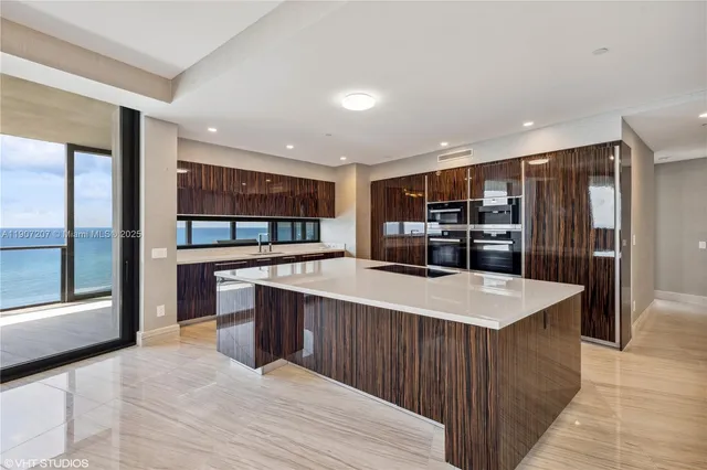 a living room with stainless steel appliances kitchen island a large island in the center