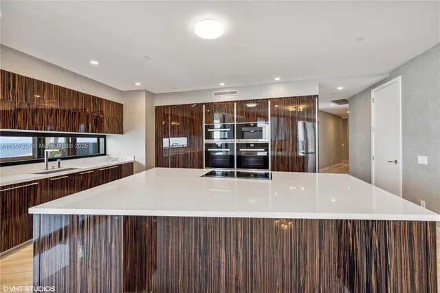a kitchen with stainless steel appliances kitchen island granite countertop a stove and a sink