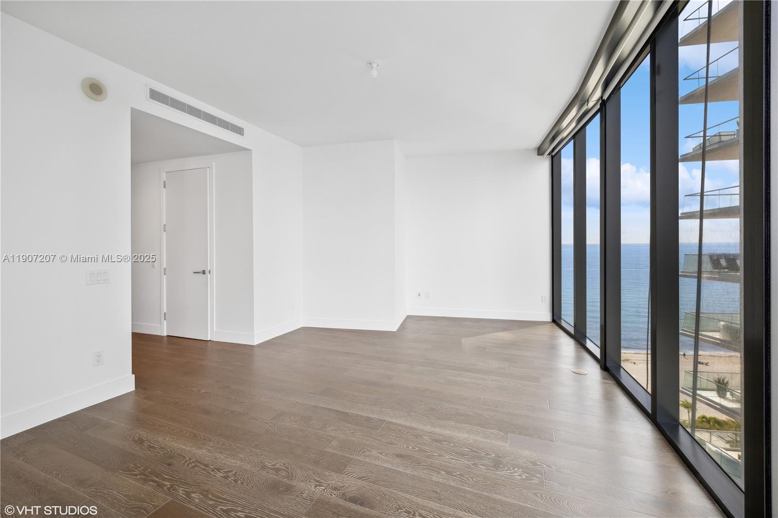 18555 Collins Avenue, Unit 1101 Sunny Isles Beach, FL 33160 - Photo 32 of 46 a view of an empty room with wooden floor and a window