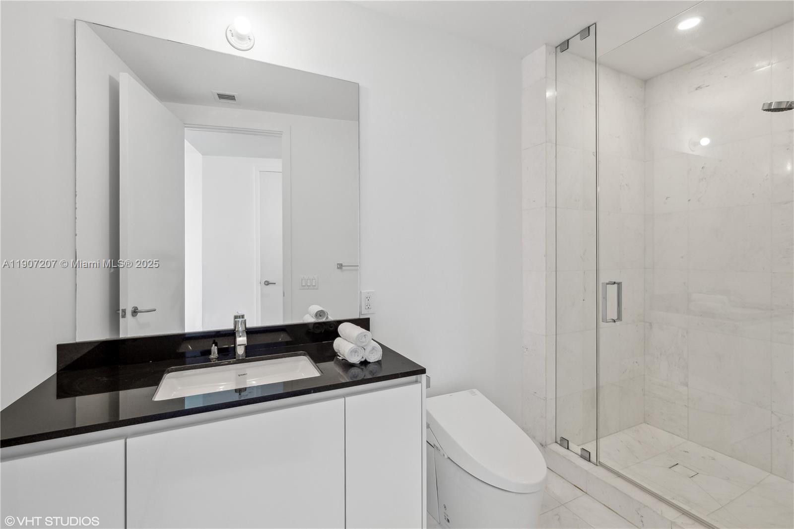 18555 Collins Avenue, Unit 1101 Sunny Isles Beach, FL 33160 - Photo 34 of 46 a bathroom with a sink a toilet and shower