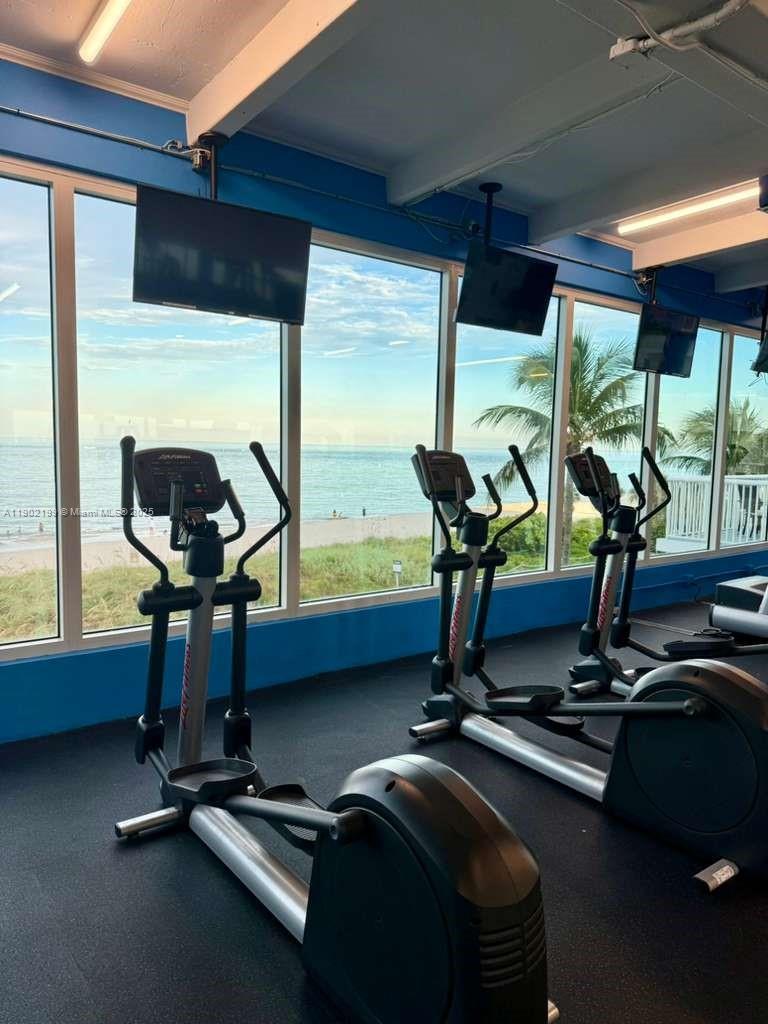 5401 Collins Avenue, Unit 131 Miami Beach, FL 33140 - Photo 23 of 33 a room with gym equipment and large windows