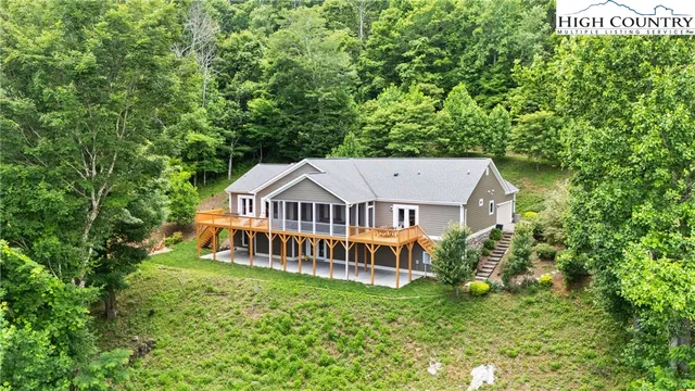 an aerial view of a house with a big yard and large trees