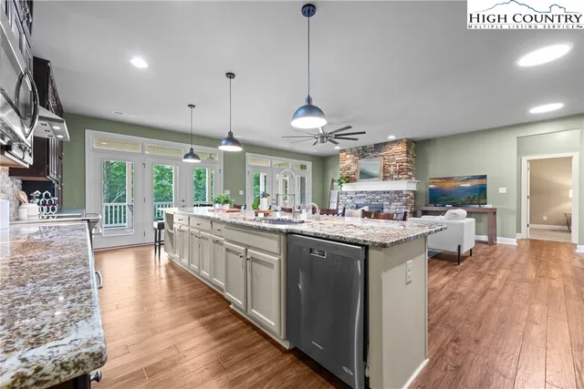 a kitchen with stainless steel appliances granite countertop a lot of counter top space and wooden floors