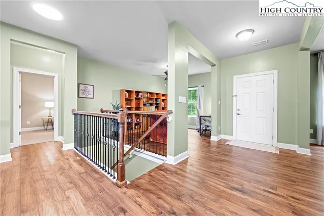 a view of a hallway with wooden floor and stairs
