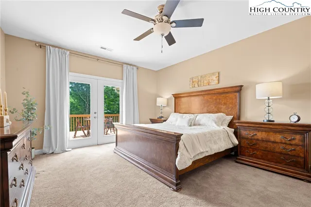 a bedroom with a large bed and a large window with the outer view