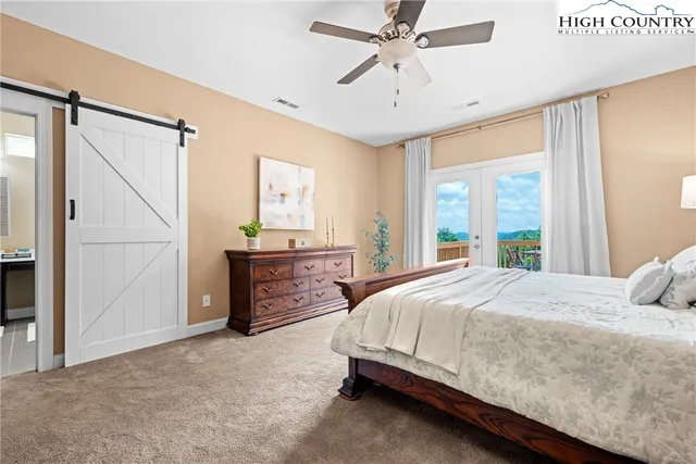 a bedroom with a bed chandelier and a window