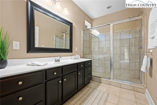 a bathroom with a double vanity sink mirror and shower