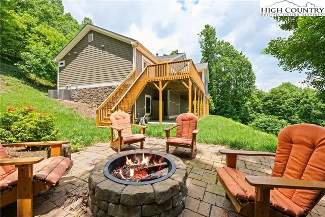 a view of a patio with a dining table and chairs with a fire pit