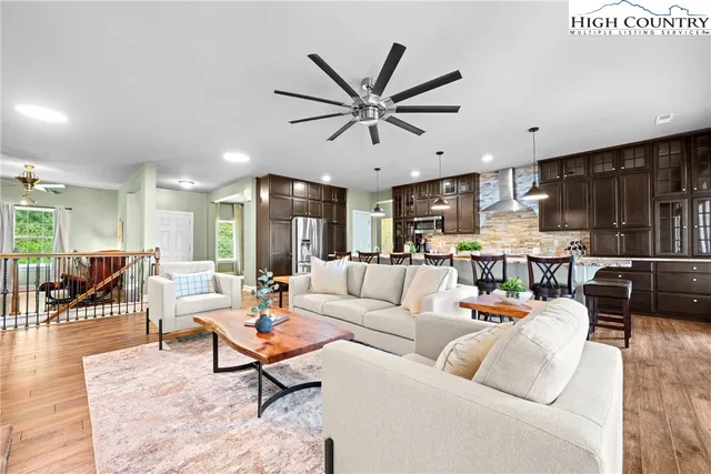 a living room with furniture kitchen view and a chandelier