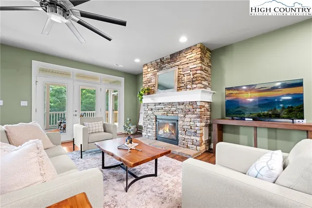 a living room with furniture a flat screen tv and a fireplace