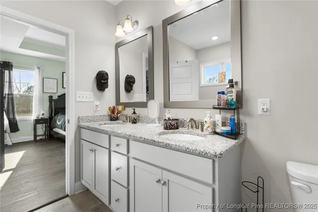 a bathroom with a granite countertop sink mirror and toilet