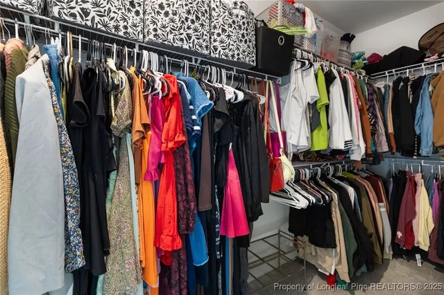 a view of walk in closet with clothes