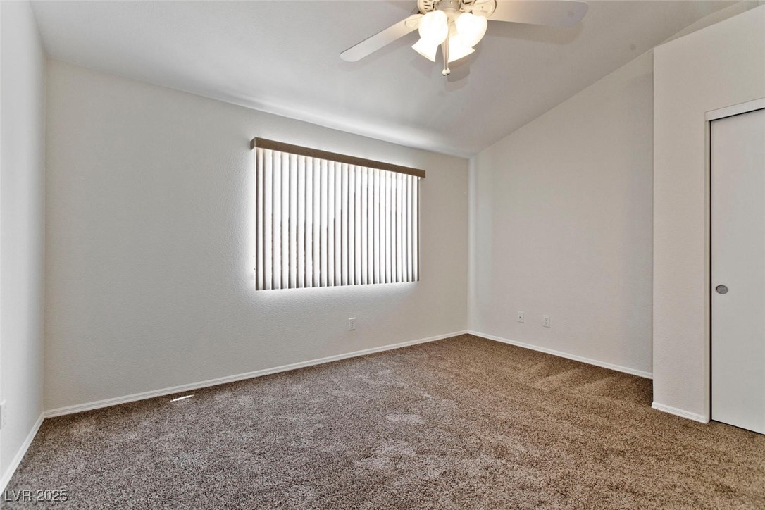 1663 Cloister Avenue Henderson, NV 89014 - Photo 25 of 35 Carpeted spare room featuring a ceiling fan and ba