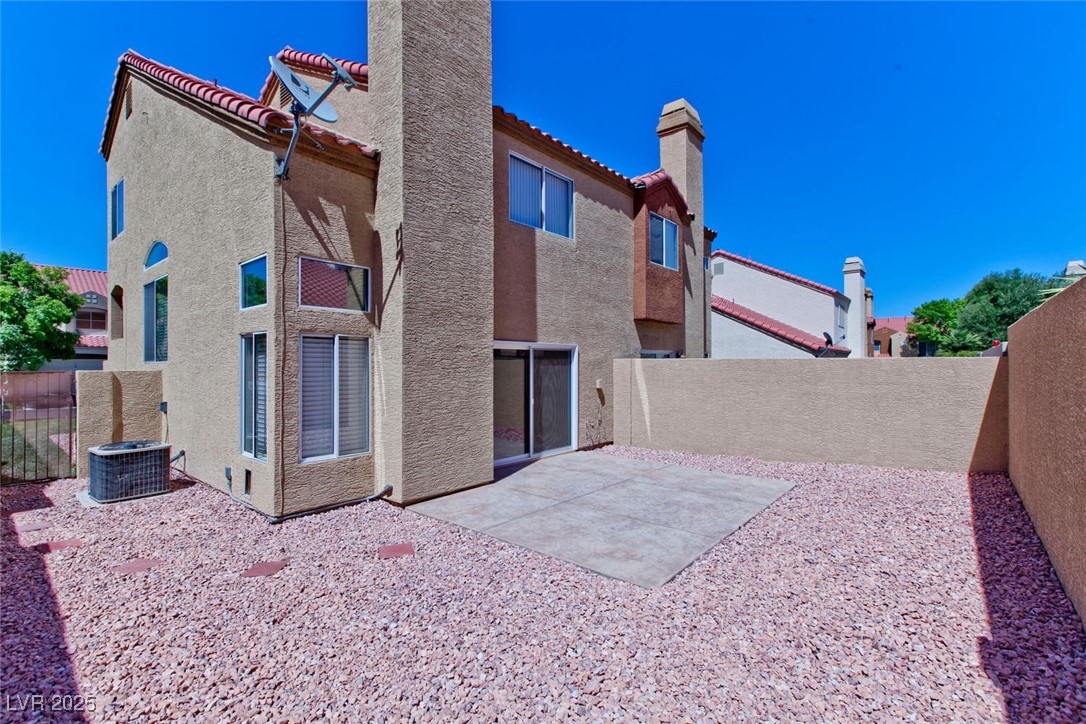 1663 Cloister Avenue Henderson, NV 89014 - Photo 32 of 35 Back of house featuring a chimney, stucco siding,