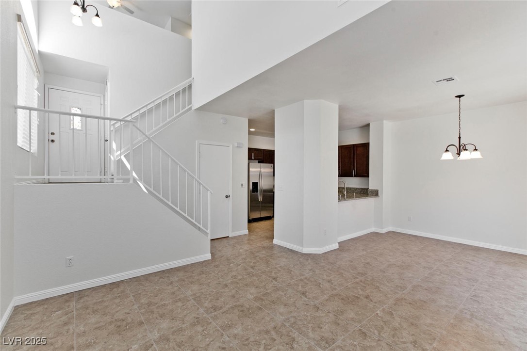 1663 Cloister Avenue Henderson, NV 89014 - Photo 6 of 35 Unfurnished living room with a chandelier and stai