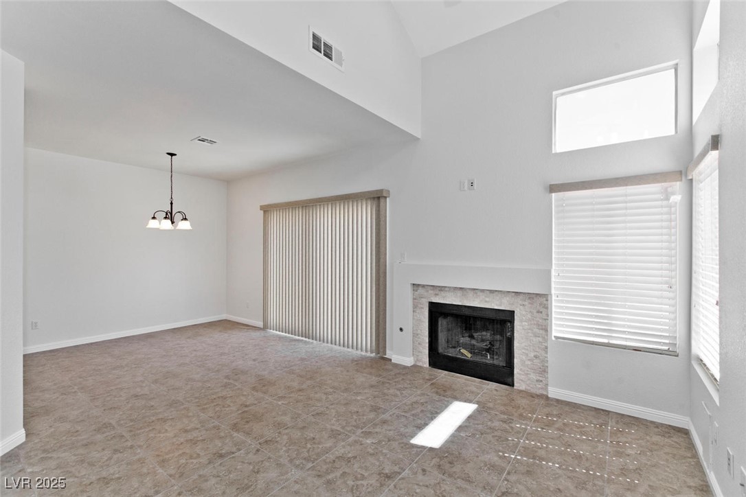 1663 Cloister Avenue Henderson, NV 89014 - Photo 7 of 35 Unfurnished living room with a chandelier, a tiled