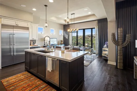a kitchen with stainless steel appliances granite countertop a sink and a refrigerator