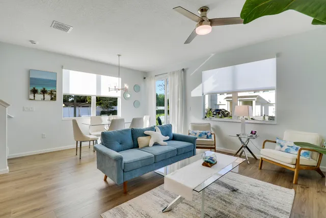 a living room with furniture a wooden floor and a chandelier