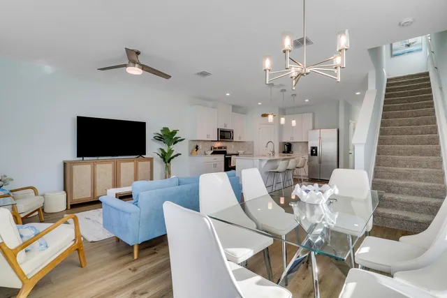 a living room with furniture a flat screen tv and kitchen view
