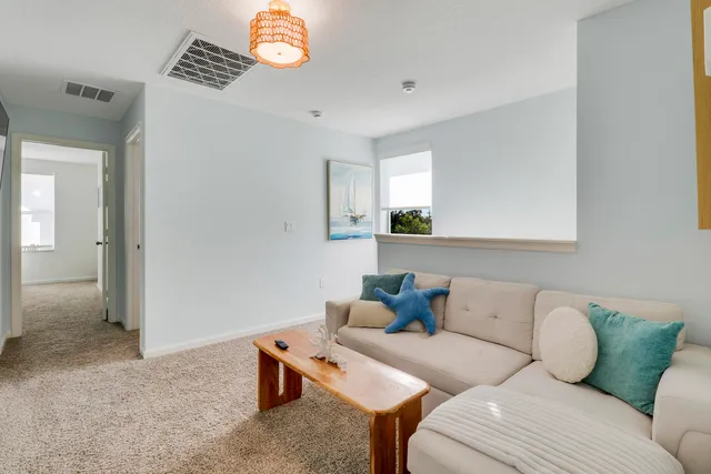 a living room with furniture a window and a flat screen tv