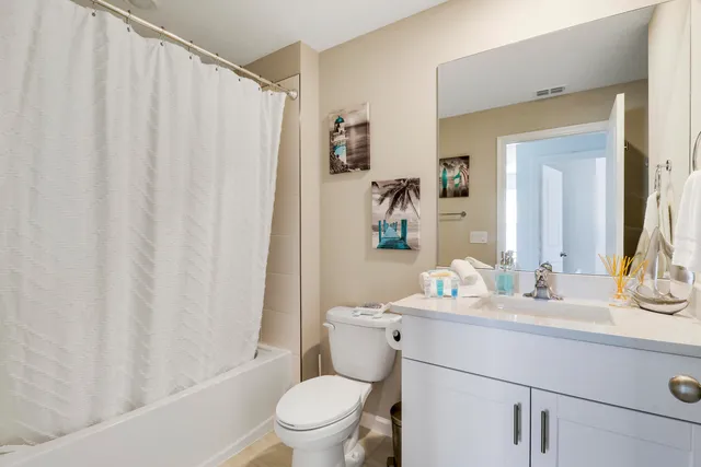 a bathroom with a sink a toilet and shower curtain