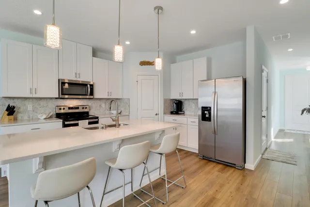 a kitchen with stainless steel appliances a refrigerator a stove a sink and a microwave