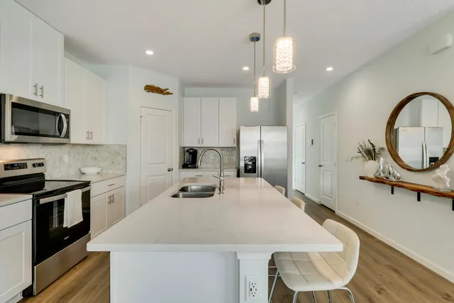 a kitchen with kitchen island a sink appliances and cabinets
