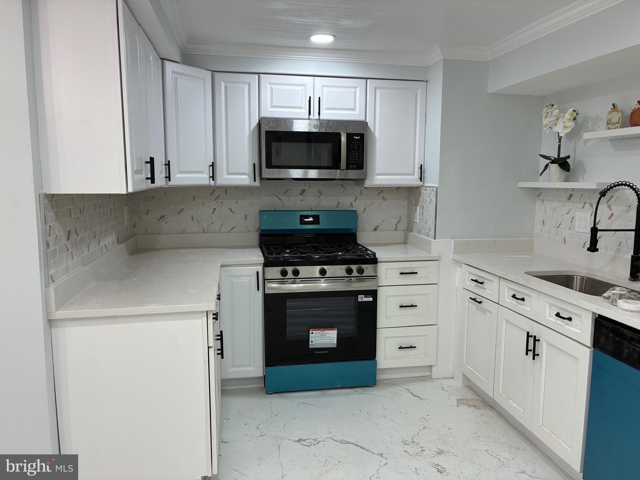 2704 Marbourne Avenue Baltimore, MD 21230 - Photo 3 of 46 a kitchen with white cabinets and stainless steel appliances