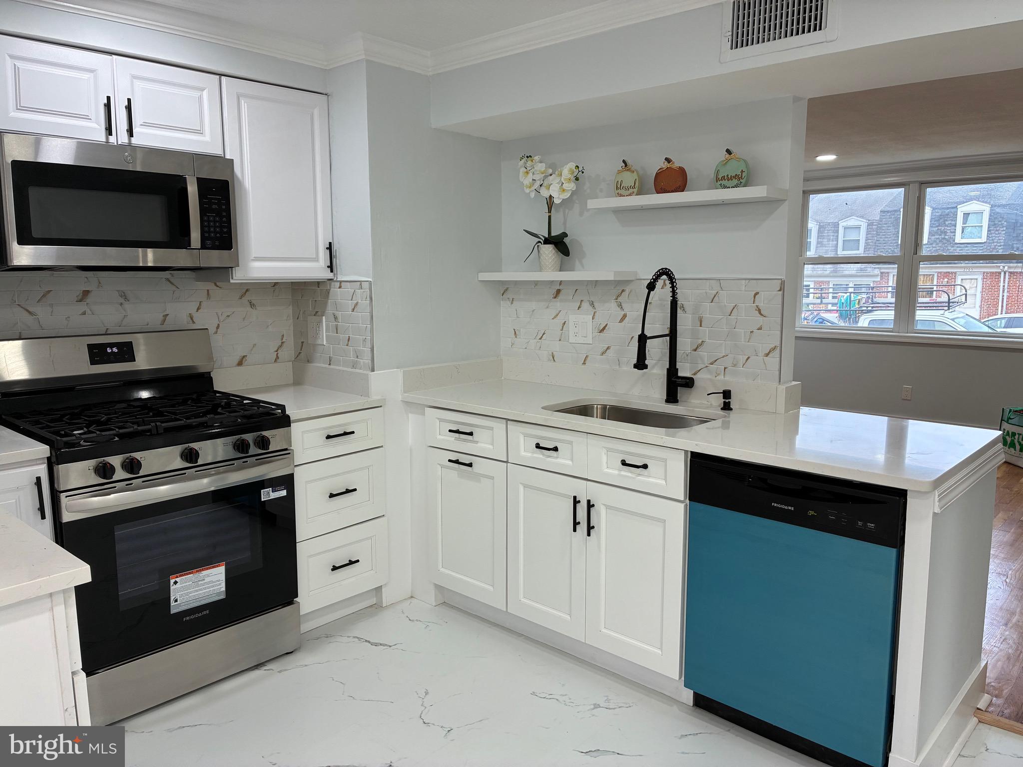 2704 Marbourne Avenue Baltimore, MD 21230 - Photo 4 of 46 a kitchen with cabinets stainless steel appliances and a window