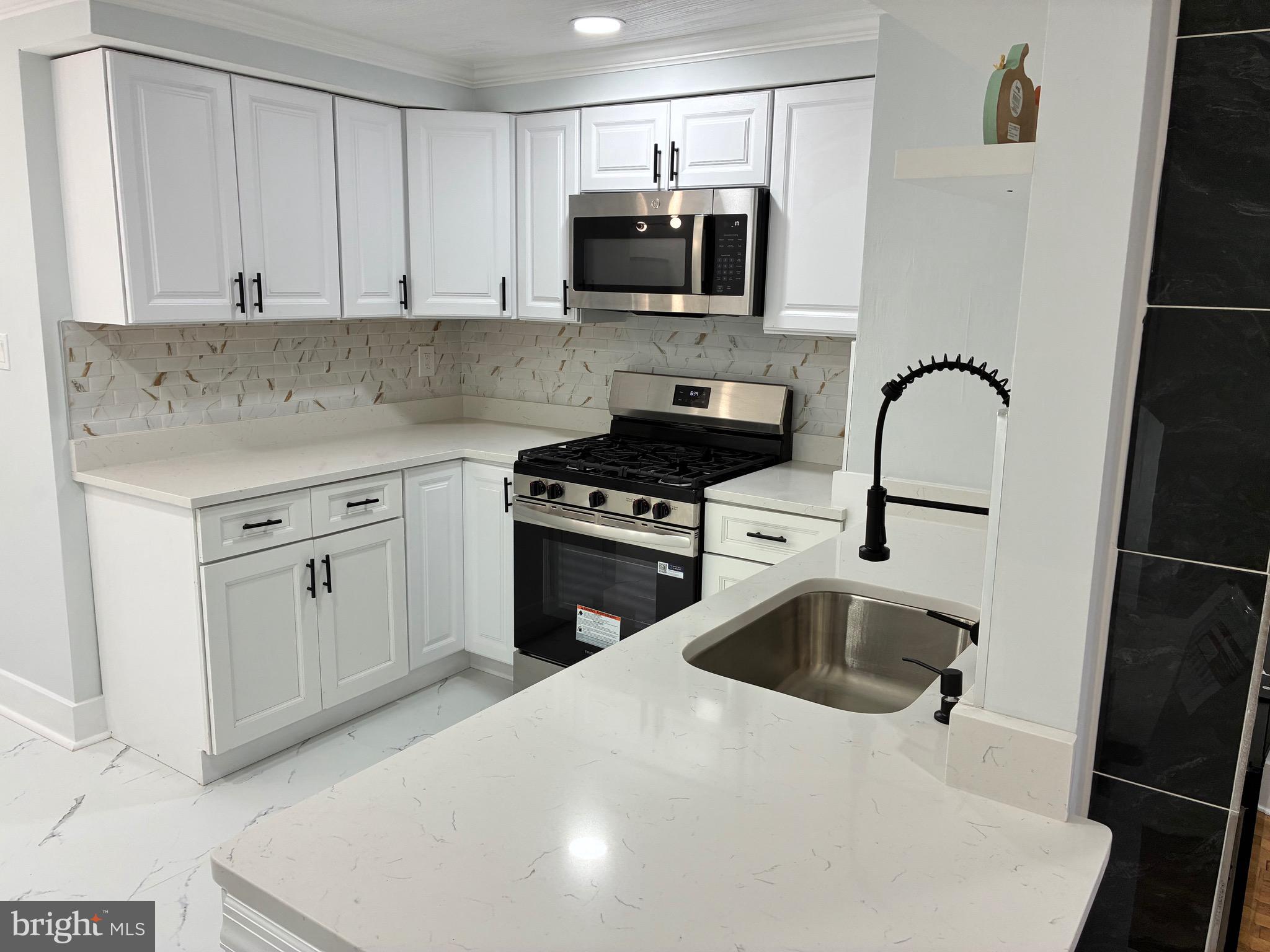 2704 Marbourne Avenue Baltimore, MD 21230 - Photo 5 of 46 a kitchen with a sink and a stove top oven
